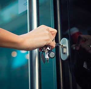Woman Opening Secure Door with Keys